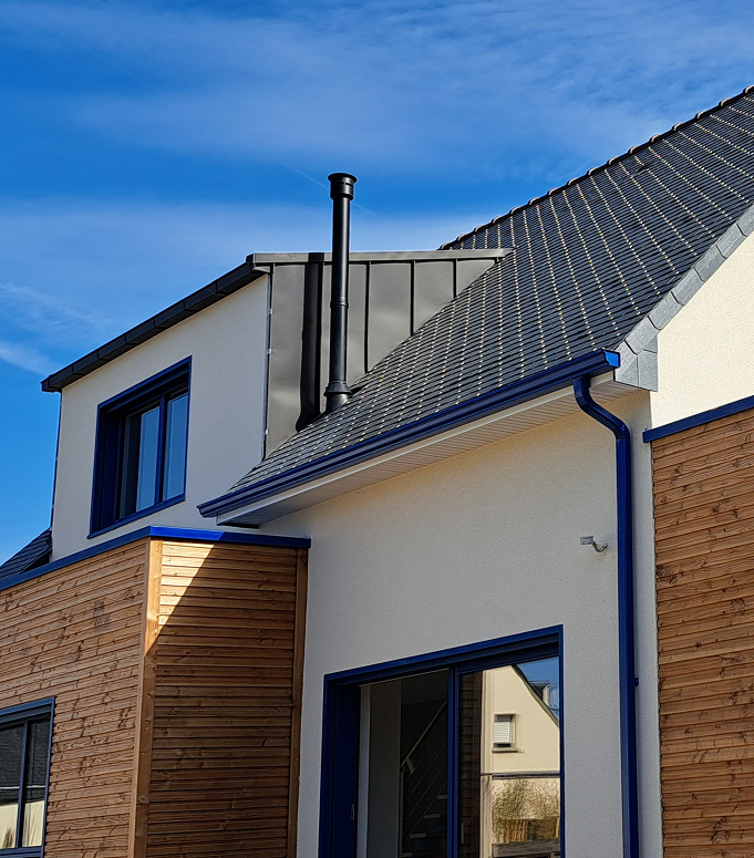 Habillage châssis en zinc naturelle anthracite, gouttières et descendants aluminium, bardage naturelle en douglas, isolation thermique par l'extérieur avec enduit gratté